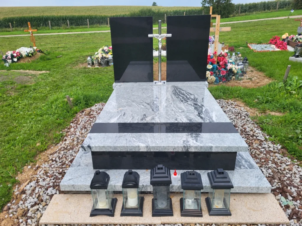 Rzeczywista realizacja A-Stone: nagrobek z jasnego granitu, dwiema ciemnymi tablicami i metalowym krzyżem